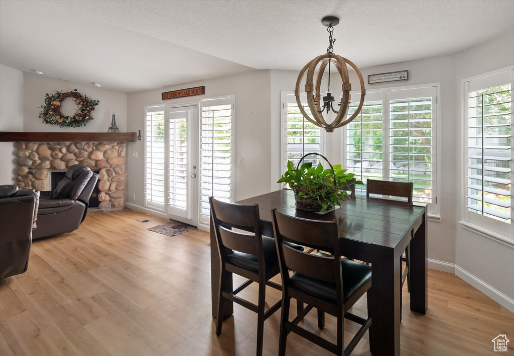Dining area featuring a chandelier, plenty of natural light, light wood-type flooring, and baseboards