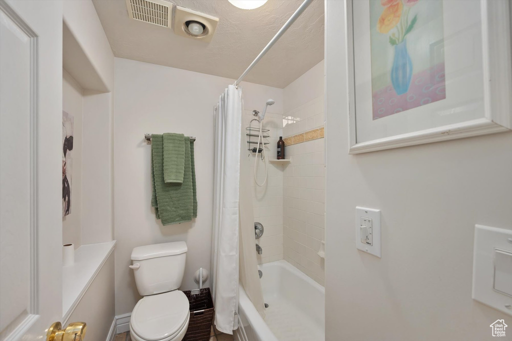 Full bath with toilet and shower / bathtub combination with curtain