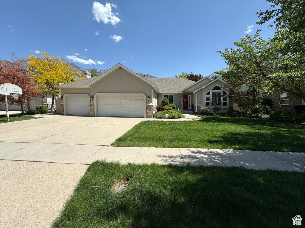 Single story home with a garage, stucco siding, a front yard, driveway, and a chimney