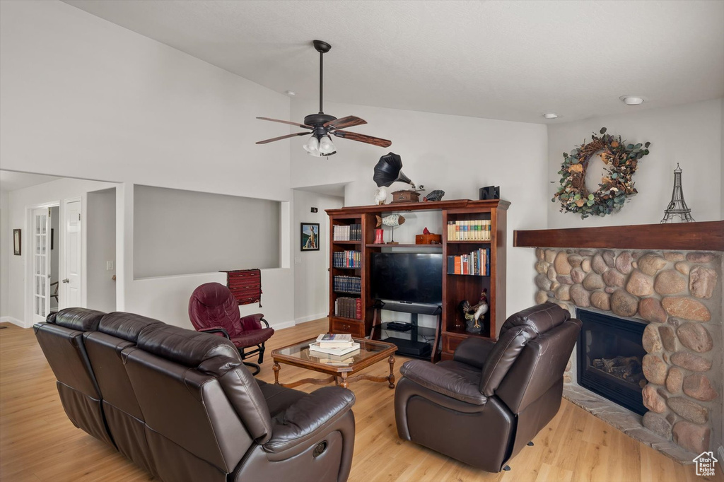 Living room featuring a ceiling fan, wood finished floors, a fireplace, and recessed lighting