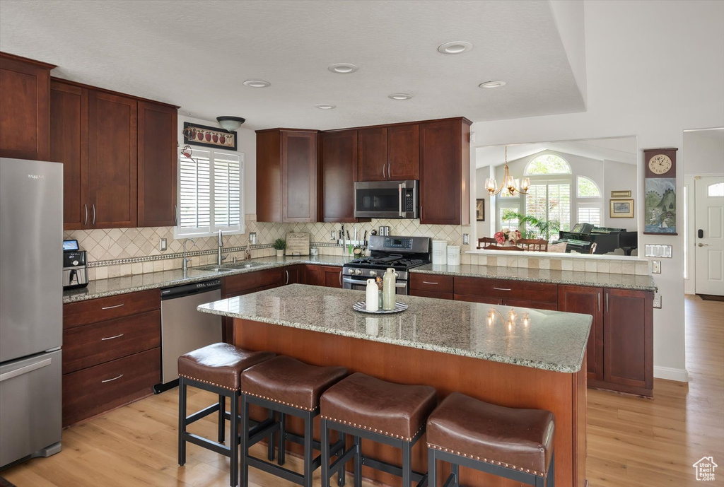 Kitchen with appliances with stainless steel finishes, tasteful backsplash, a chandelier, a sink, and recessed lighting
