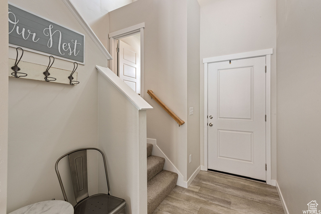 Stairs with wood finished floors and baseboards