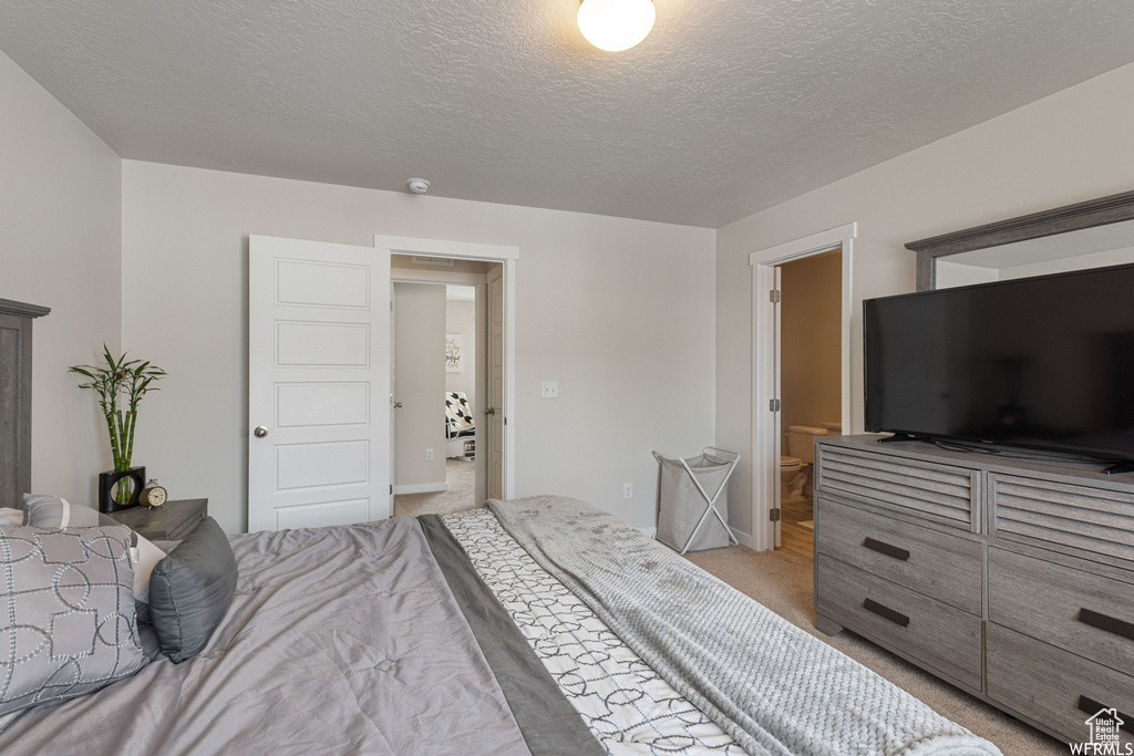 Bedroom with light carpet and a textured ceiling
