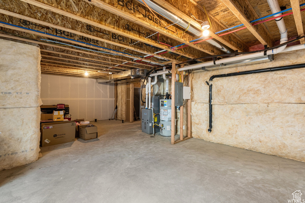 Unfinished below grade area featuring secured water heater and electric panel