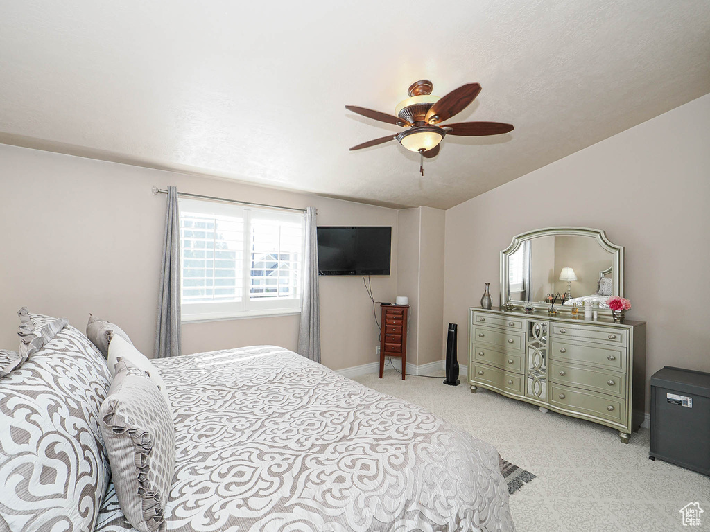 Bedroom with light colored carpet, ceiling fan, and lofted ceiling