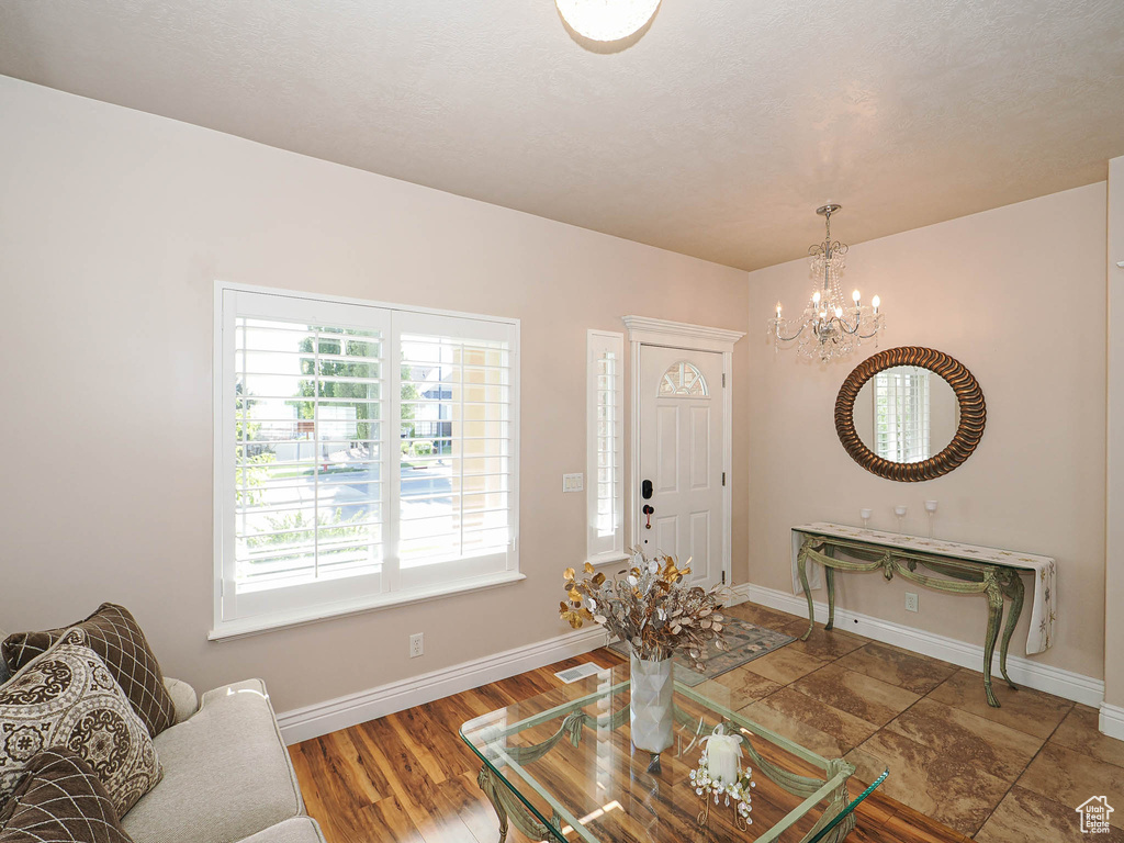 Living room featuring a chandelier, baseboards, and wood finished floors