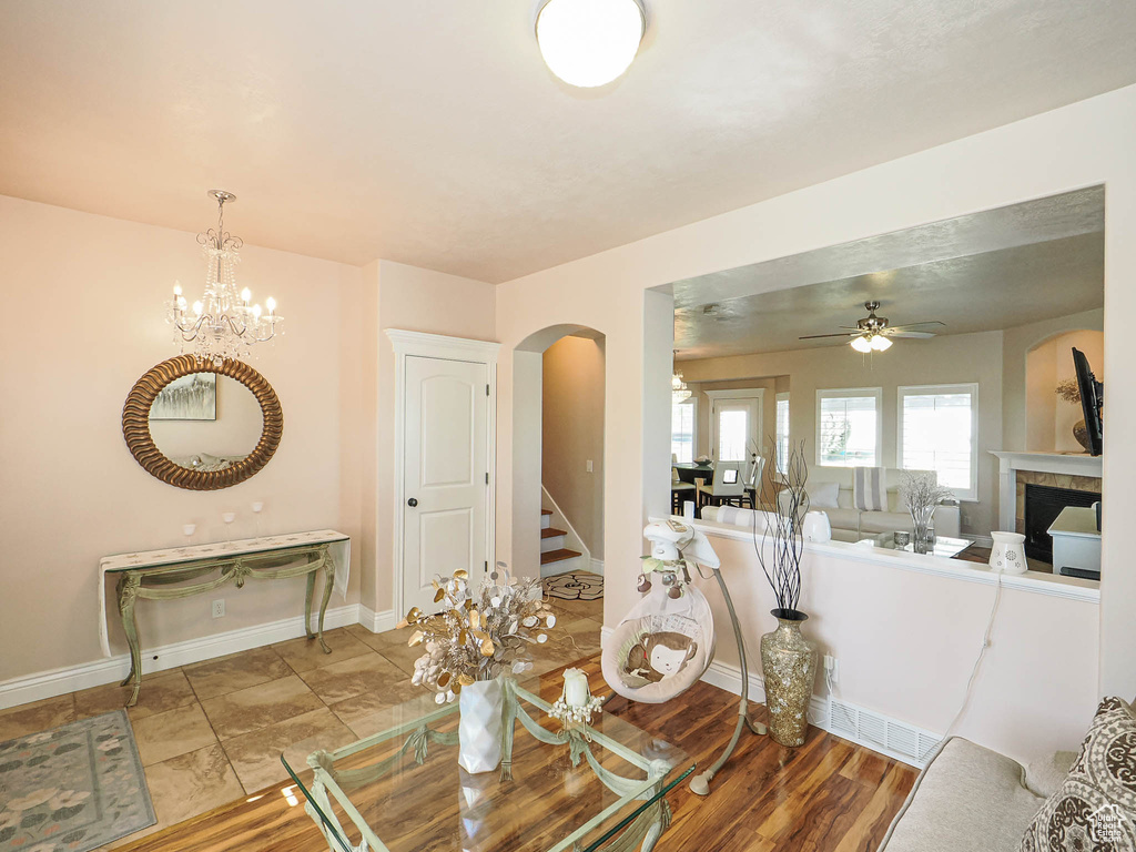 Living area featuring arched walkways, a chandelier, a ceiling fan, baseboards, and stairs