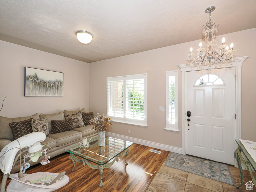Entryway featuring a chandelier, wood finished floors, and baseboards