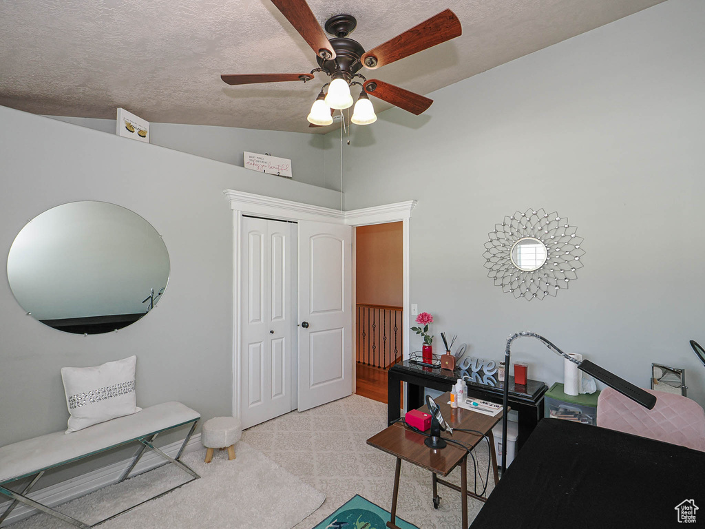 Sitting room featuring lofted ceiling, a ceiling fan, carpet, a textured ceiling, and baseboards
