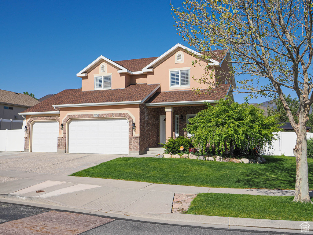 View of front of property featuring driveway, stucco siding, and a garage