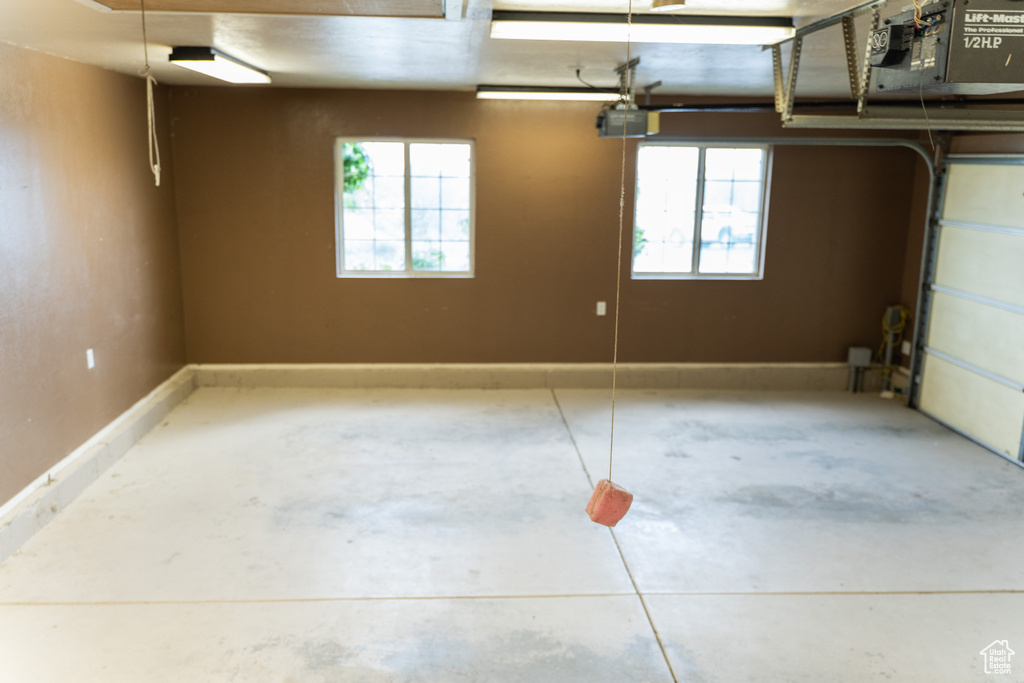 Garage featuring a garage door opener and baseboards