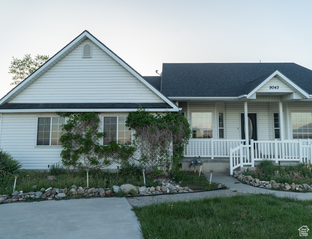 View of front of home featuring covered porch and roof with shingles