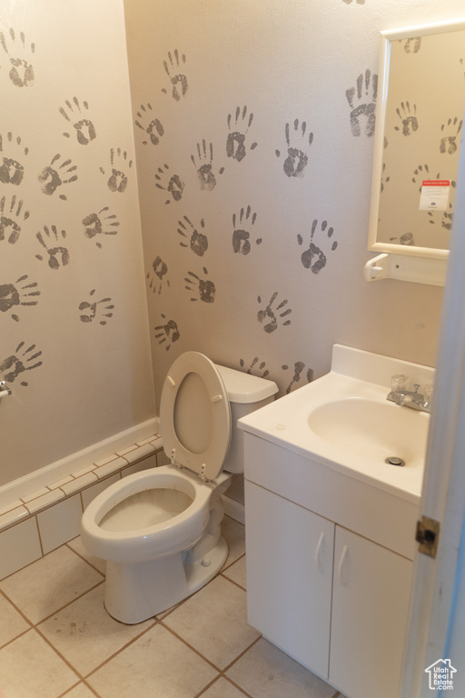 Bathroom featuring toilet, vanity, and tile patterned floors