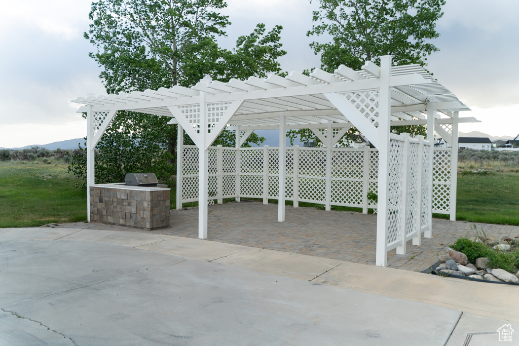 View of patio featuring area for grilling and a pergola