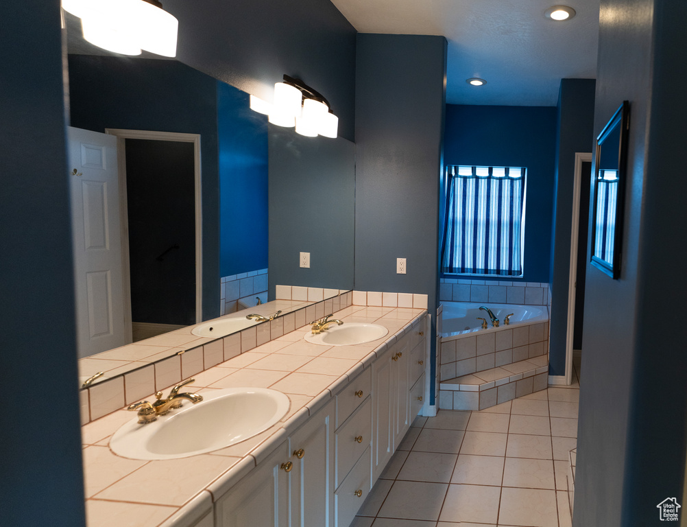 Full bathroom featuring tile patterned floors, a garden tub, double vanity, and recessed lighting
