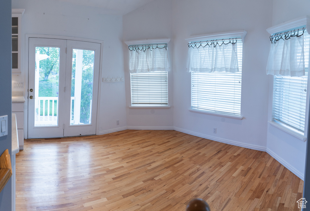 Interior space with light wood finished floors, baseboards, and vaulted ceiling