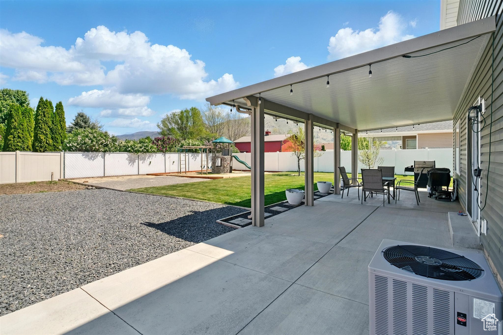View of patio featuring a playground, central AC unit, and outdoor dining area