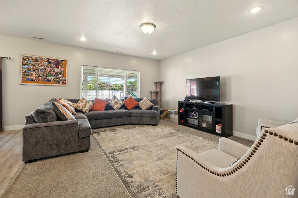 Living room featuring baseboards, wood finished floors, and recessed lighting