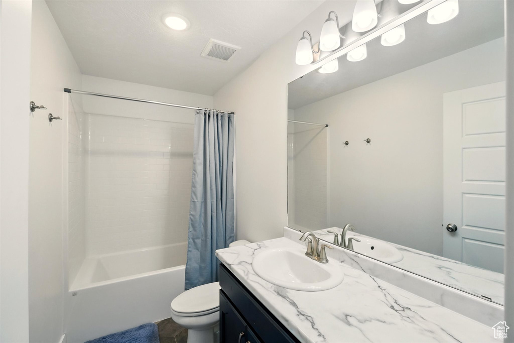 Full bath with toilet, shower / bath combo, and vanity
