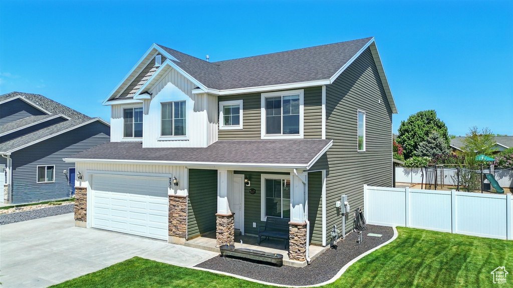 Craftsman house featuring stone siding, driveway, roof with shingles, and covered porch
