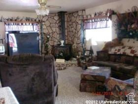 Carpeted living area featuring a wood stove and a ceiling fan