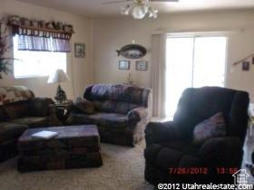 Carpeted living area featuring plenty of natural light and ceiling fan