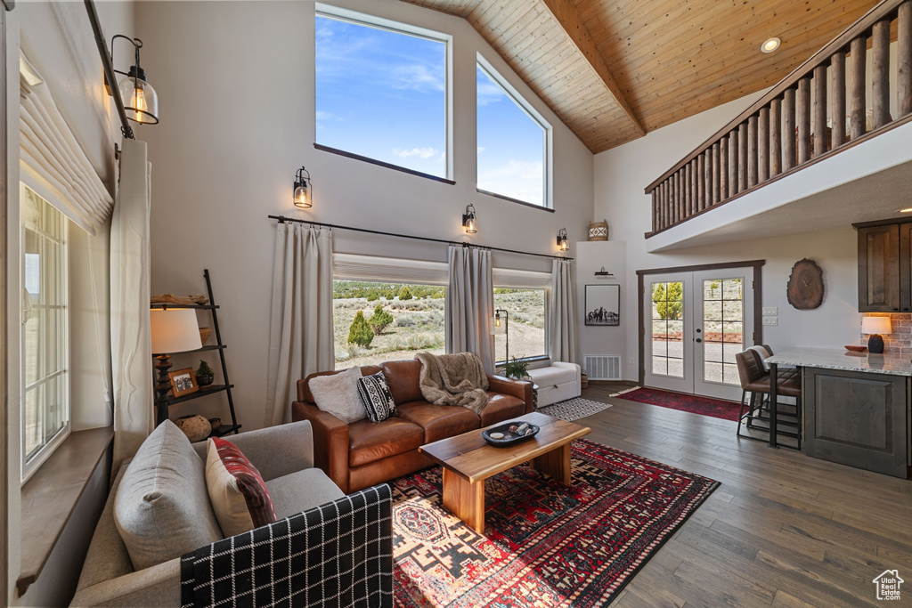 Living area with french doors, high vaulted ceiling, healthy amount of natural light, dark wood-style floors, and wooden ceiling