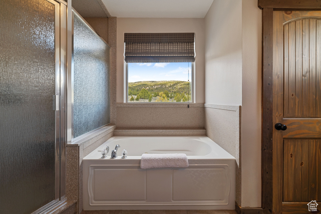 Full bath featuring a bath and a shower stall