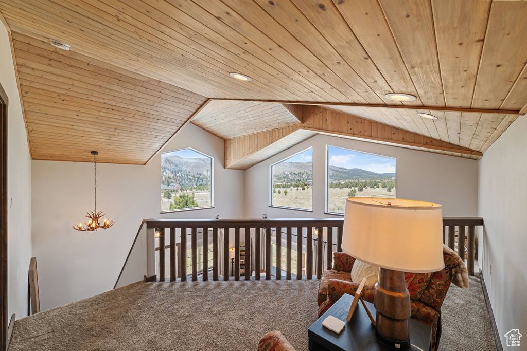 Bonus room with wood ceiling, carpet flooring, a chandelier, lofted ceiling, and a mountain view