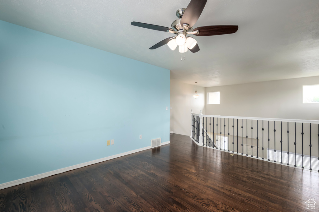 Unfurnished room featuring wood finished floors, ceiling fan, and baseboards