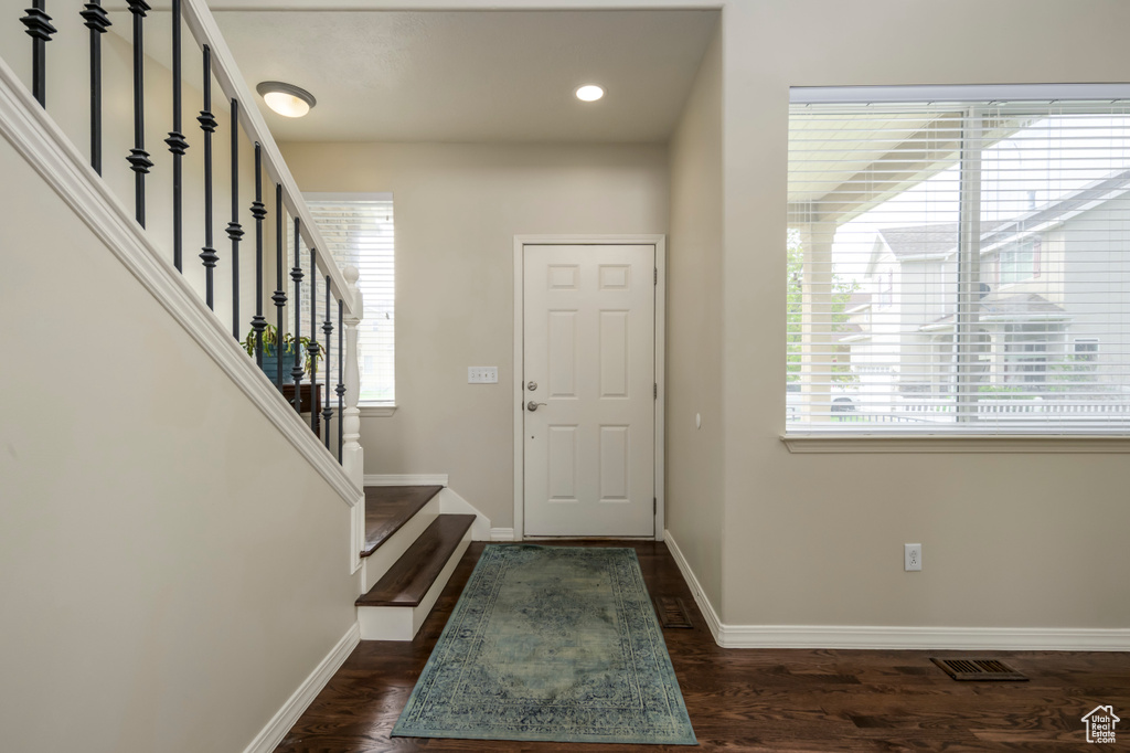 Entrance foyer featuring baseboards, stairway, recessed lighting, and dark wood-style flooring