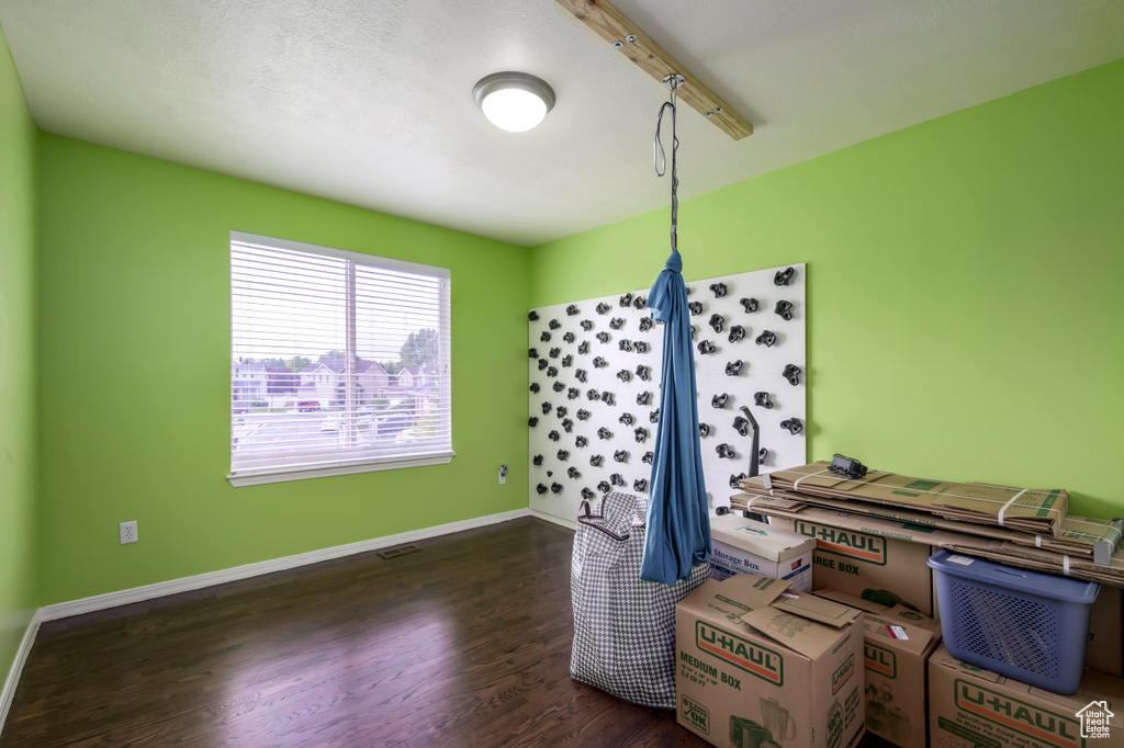 Miscellaneous room featuring dark wood finished floors and baseboards