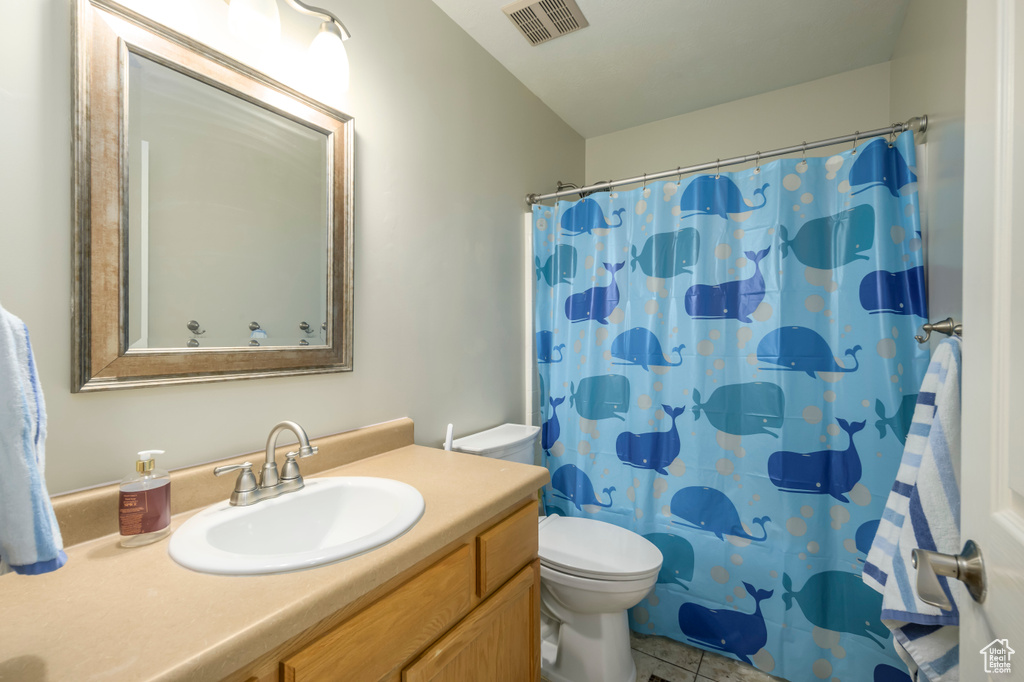 Full bathroom with vanity, toilet, a shower with shower curtain, and tile patterned floors