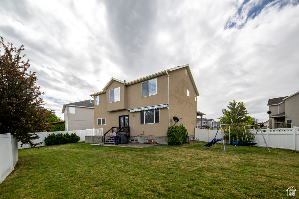 Back of property with a playground and stucco siding