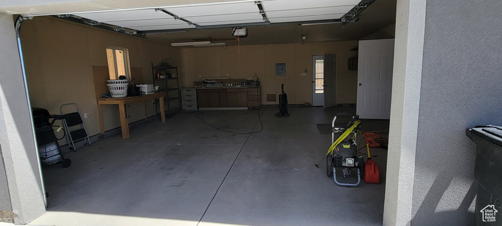 Garage featuring a garage door opener and electric panel