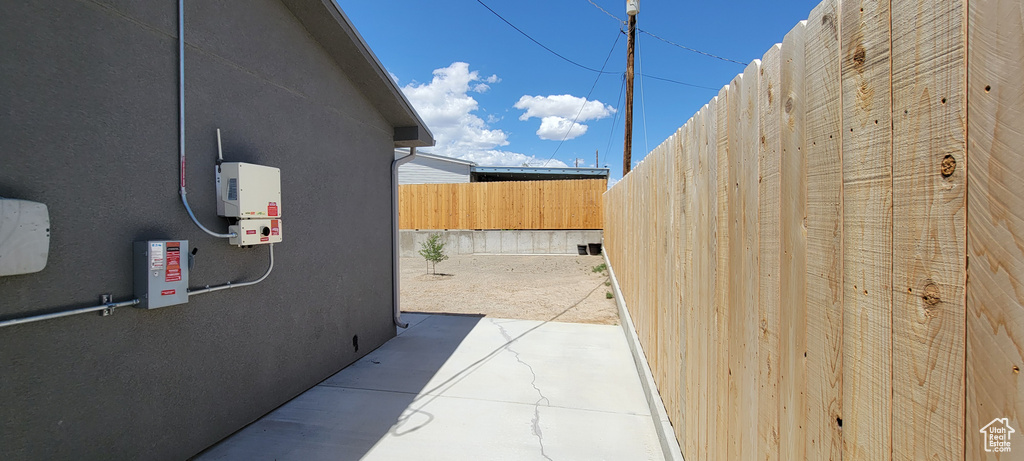 View of side of home featuring fence and stucco siding
