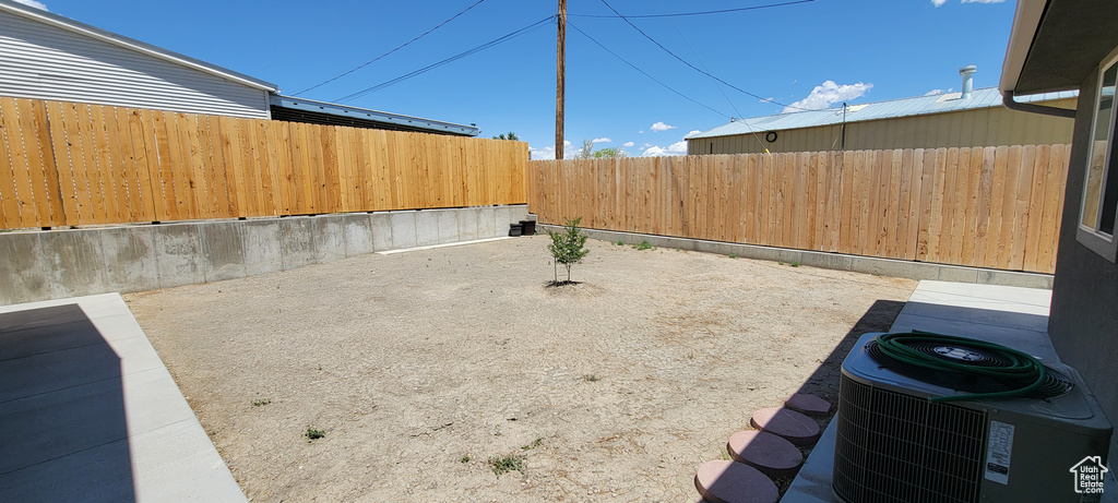 Fenced backyard with central air condition unit and a patio area