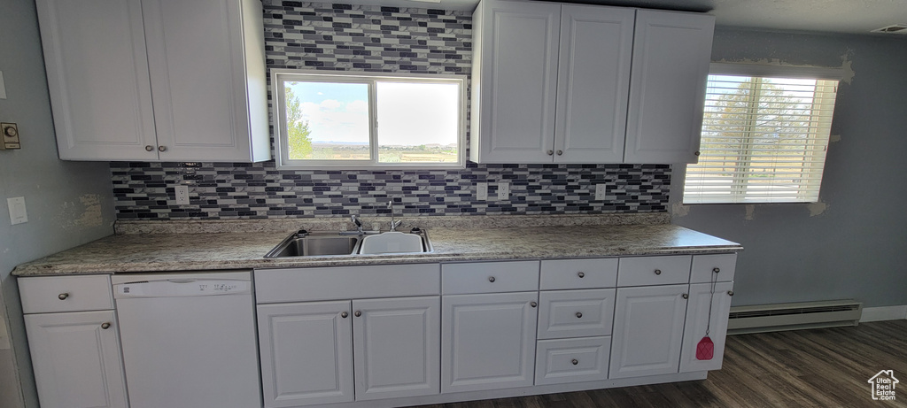 Kitchen featuring dishwasher, baseboard heating, a sink, white cabinets, and tasteful backsplash