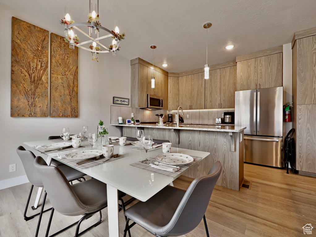 Dining space with light wood-style flooring, a chandelier, recessed lighting, and baseboards