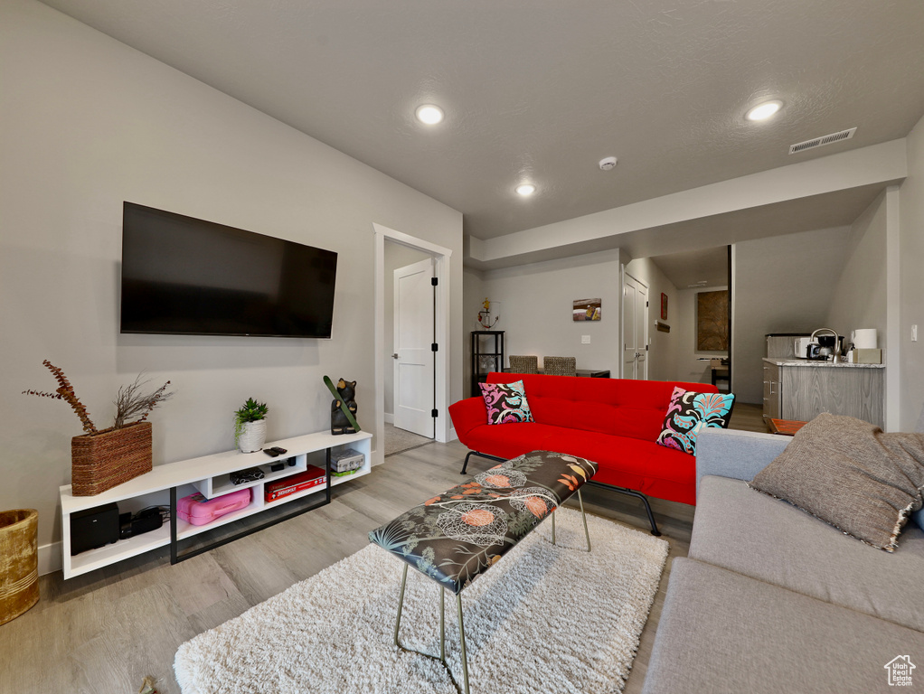 Living room featuring wood finished floors, recessed lighting, and baseboards