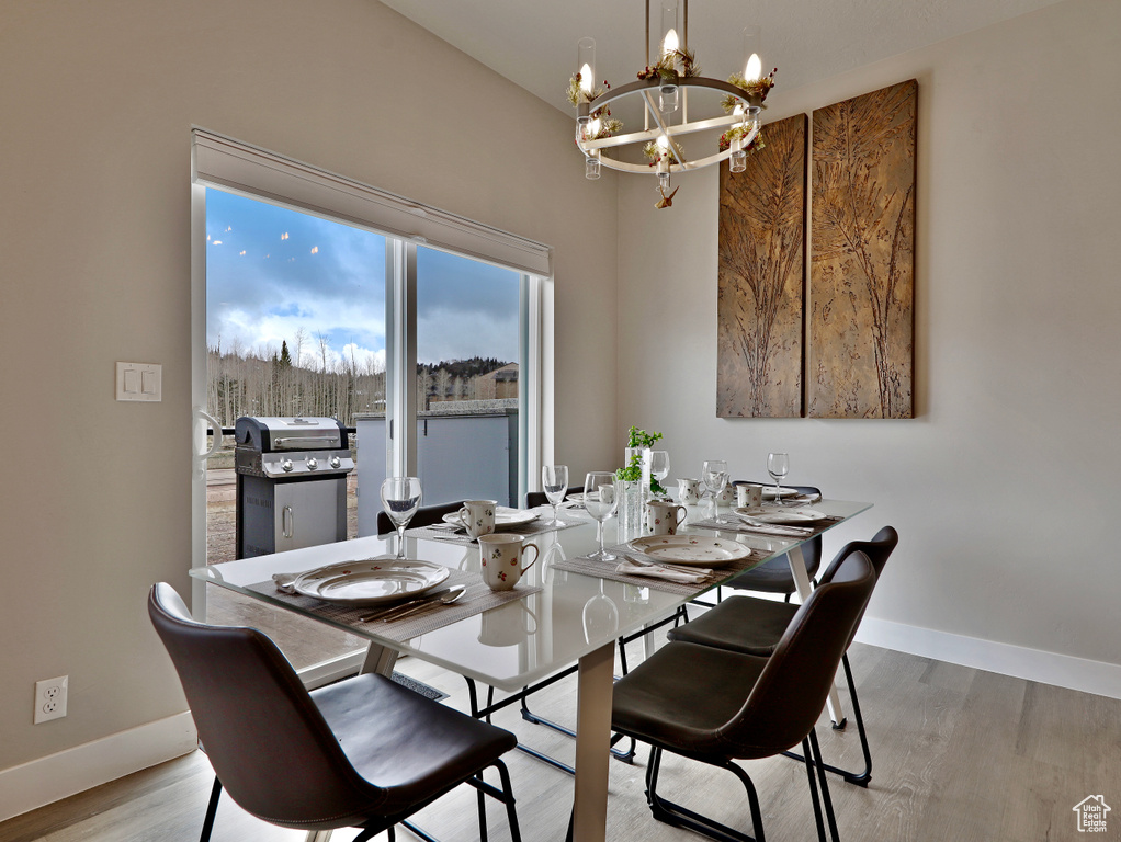 Dining area featuring a chandelier, baseboards, and light wood-type flooring