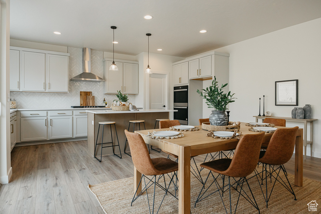 Dining space with light wood-type flooring and recessed lighting