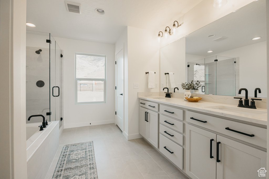 Full bathroom with a shower stall, double vanity, a garden tub, baseboards, and recessed lighting