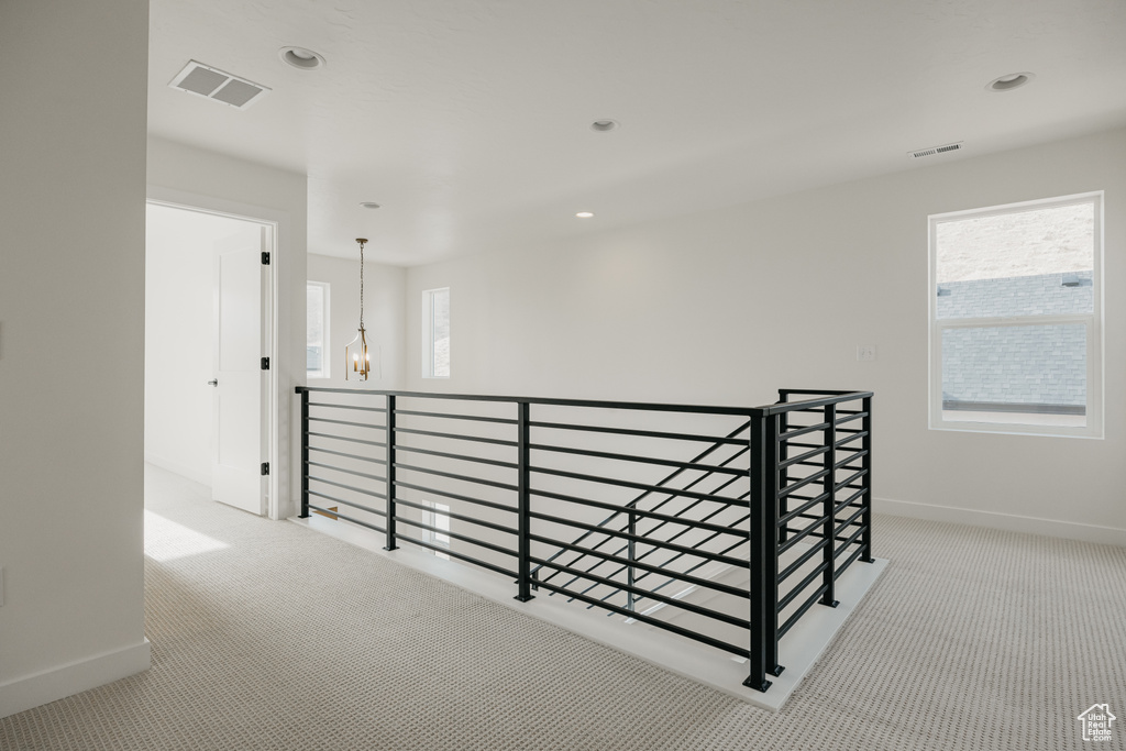 Corridor featuring an upstairs landing, carpet flooring, baseboards, recessed lighting, and a chandelier