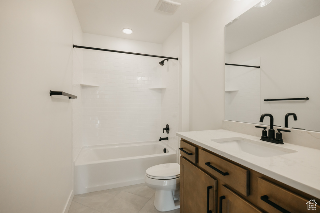 Bathroom featuring tile patterned flooring, toilet, vanity, and shower / bathtub combination