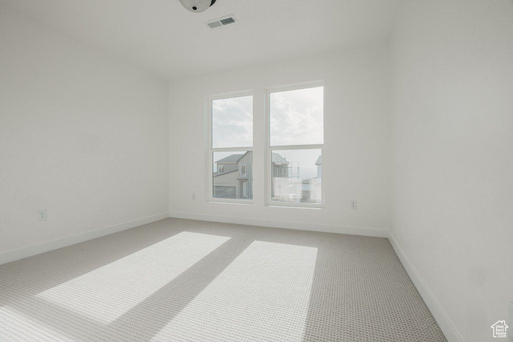 Spare room featuring light colored carpet and baseboards