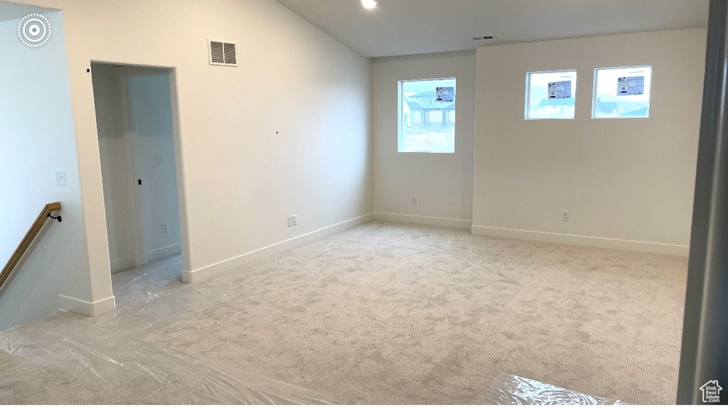 Spare room with carpet floors, baseboards, and vaulted ceiling