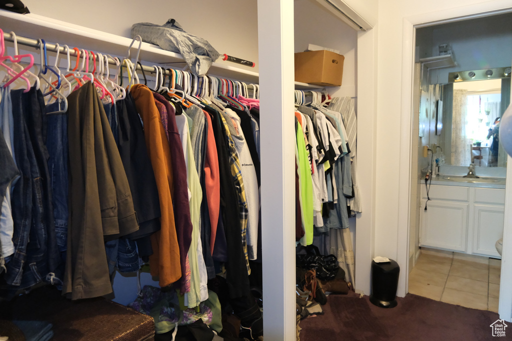Spacious closet featuring tile patterned floors, a sink, and carpet flooring