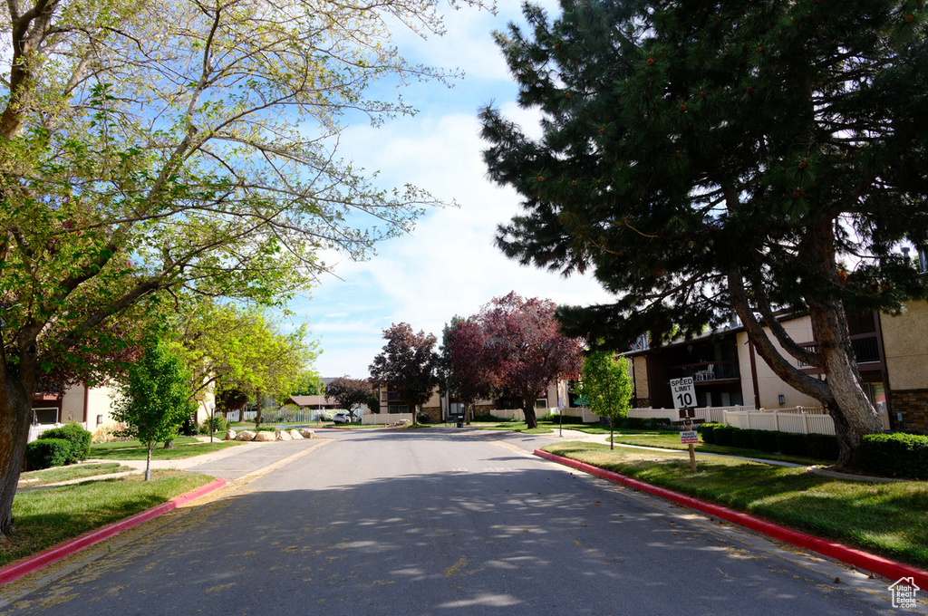 View of asphalt road featuring curbs and sidewalks