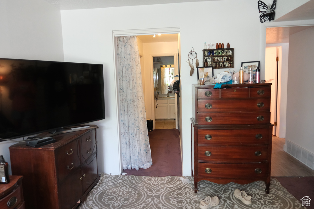 Bedroom with connected bathroom and wood finished floors